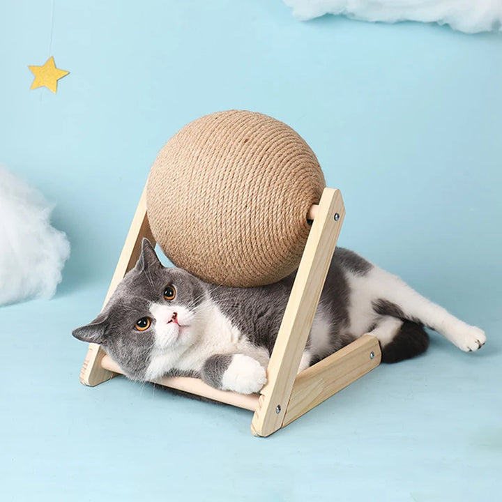 Cat lying under cat scratching ball toy
