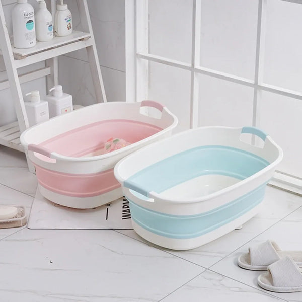 Collapsible dog bath tubs in pink and blue on a bathroom floor, shown with cleaning supplies