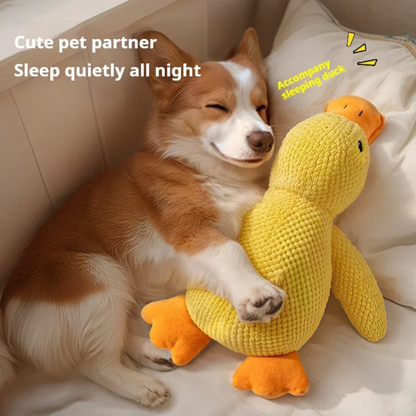 Dog Plush Toy duck on bed with dog, promotes quiet sleep.